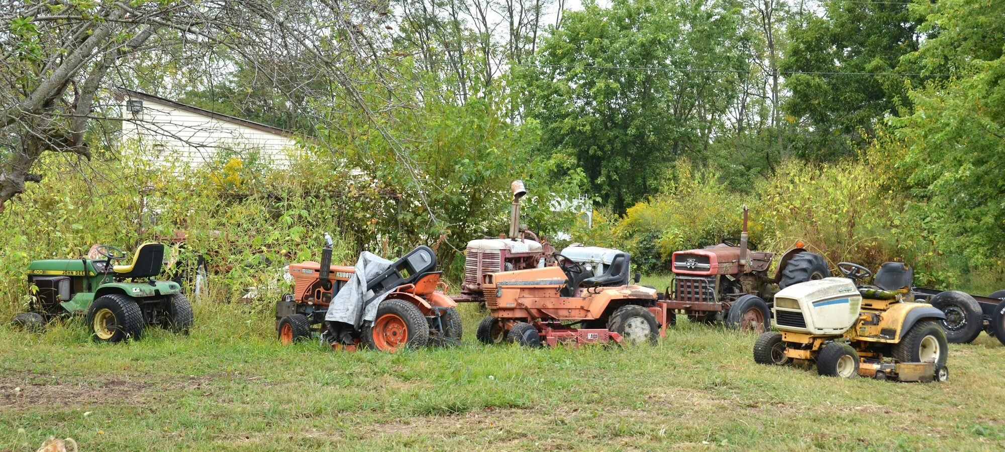 Lineup of mowers & garden tractors in a field